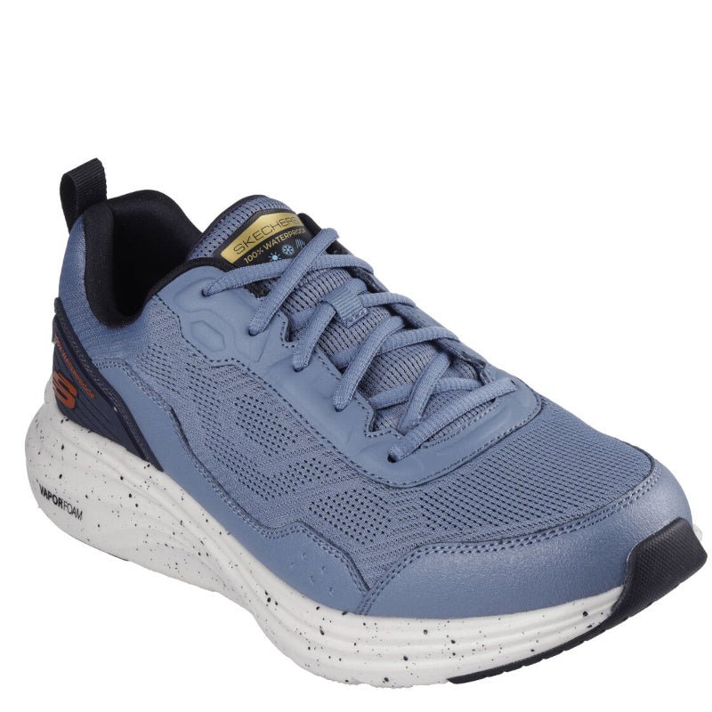 Skechers sneaker i lyseblå med sort og orange detaljer til herre.Den har en let, stødabsorberende mellemsål med sorte stænk samt åndbart mesh-overdel for komfort. Skoen er 100% vandtæt, velegnet til både hverdagsbrug og udendørs aktiviteter.
