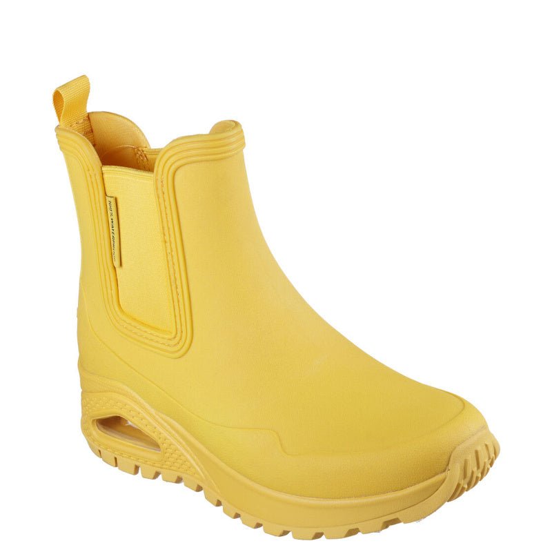 Skechers gummistøvle ien gul er en stilfuld og funktionel gummistøvle til kvinder, designet til at kombinere komfort med et moderne udseende. Den har en vandtæt syntetisk overdel og en praktisk slip-on pasform, hvilket gør den nem at tage af og på. Indersålen er polstret med Skechers Air-Cooled Memory Foam®, som giver åndbar komfort og trykaflastning. Mellemsålen er udstyret med , der tilbyder ekstra stødabsorbering. Ydersålen er fleksibel og giver godt greb, hvilket gør støvlen velegnet til både bybrug og 